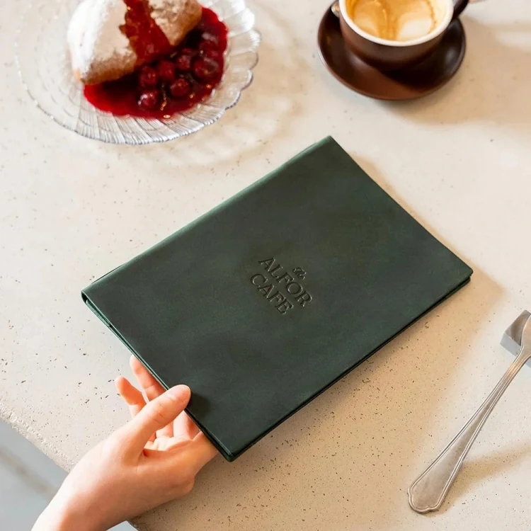 Gilt logo detail on the dark green leather cover