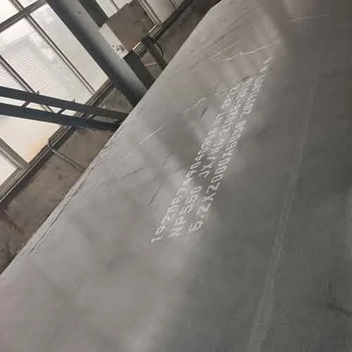 large gray steel plate leaning inside a daylit workshop