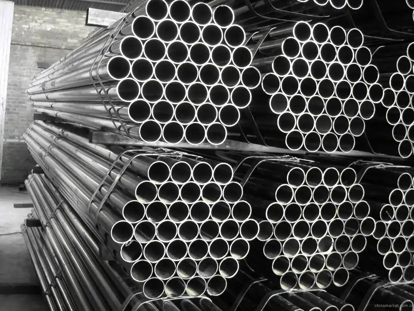 Stacked steel round pipes viewed end-on in tight bundles