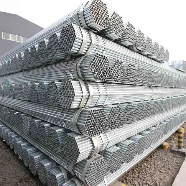 Pile of galvanized round steel pipes on gravel ground