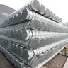 Pile of galvanized round steel pipes on gravel ground