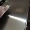 Close-up of a brushed stainless steel sheet catching the light