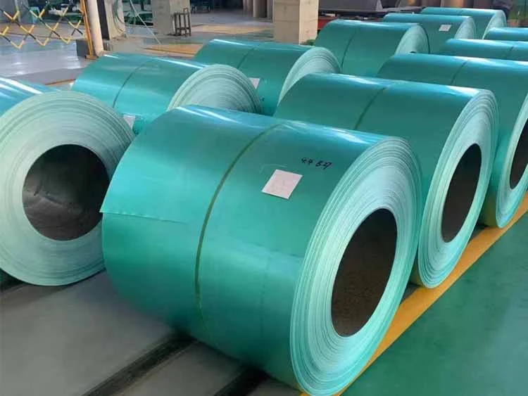 Rows of green pre-painted steel coils stored indoors