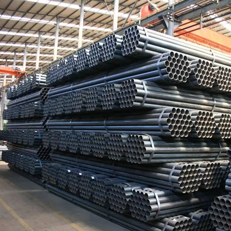 Bundles of black round steel pipes racked in a warehouse