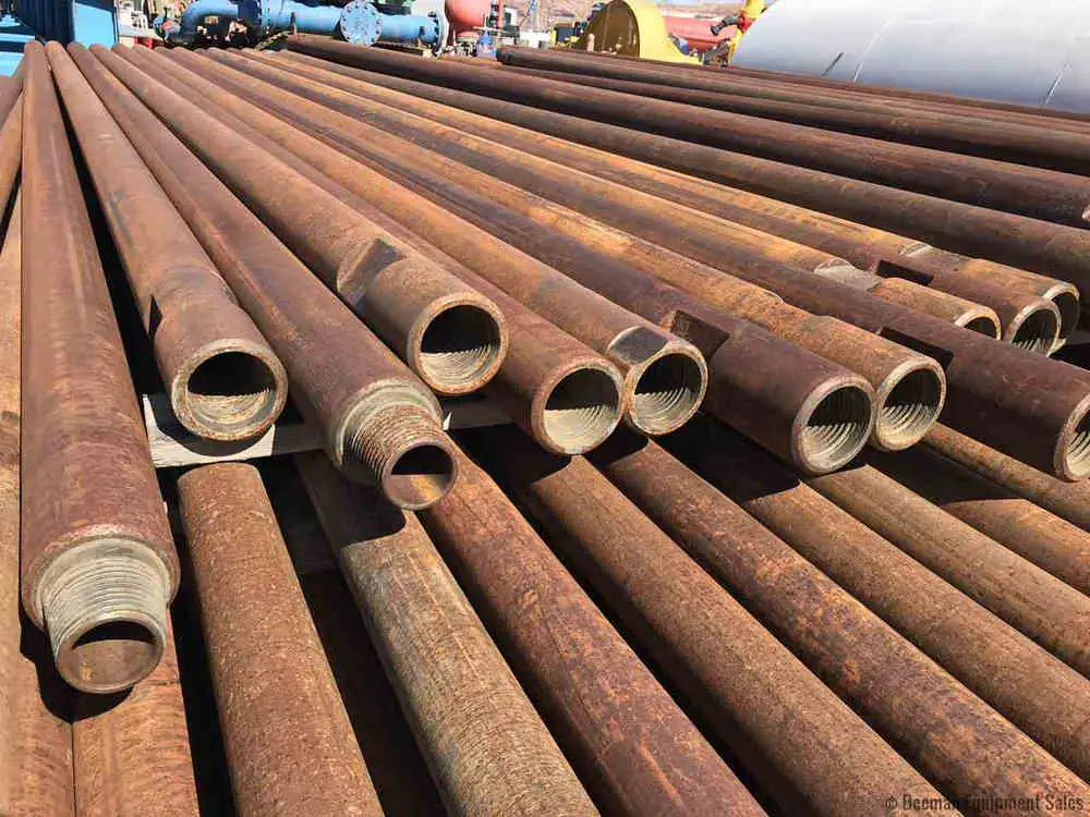Cut ends of thick-walled rusty steel pipes stacked in a pile