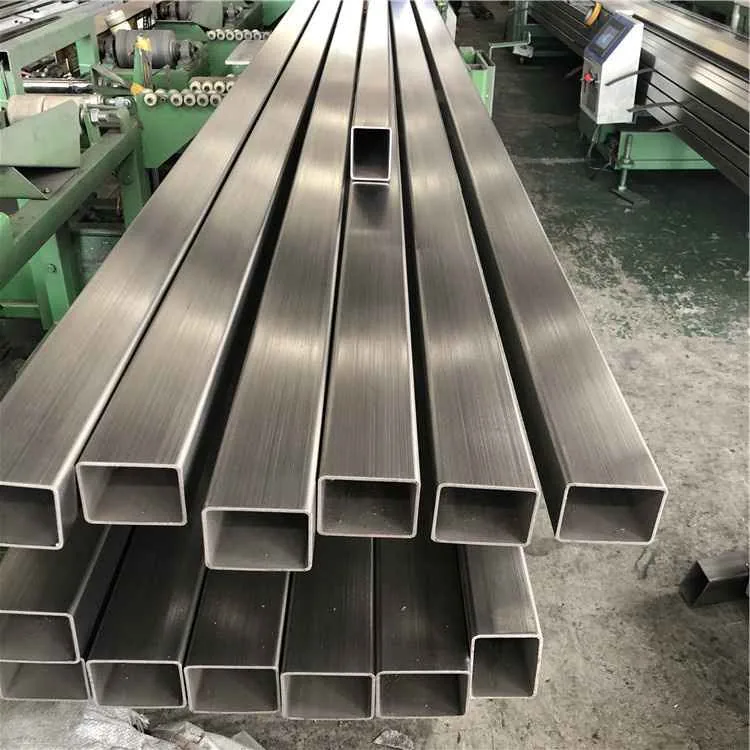 Stainless steel square tubes stacked in a workshop aisle
