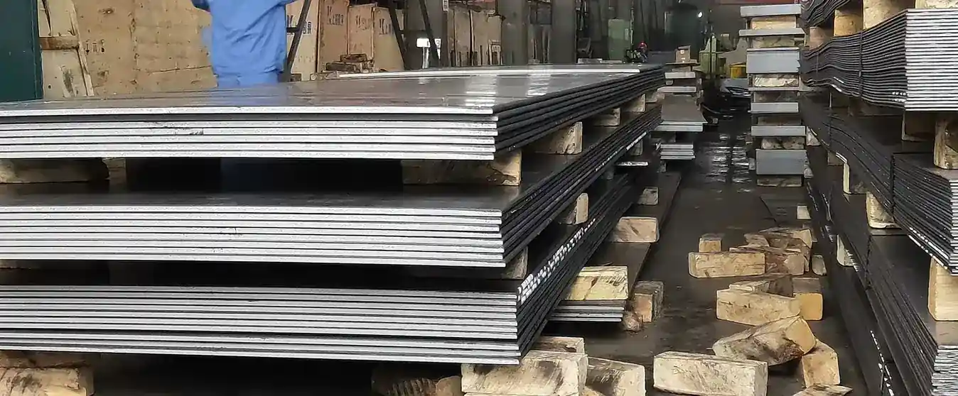 Stacked steel sheets resting on timber dunnage in a workshop