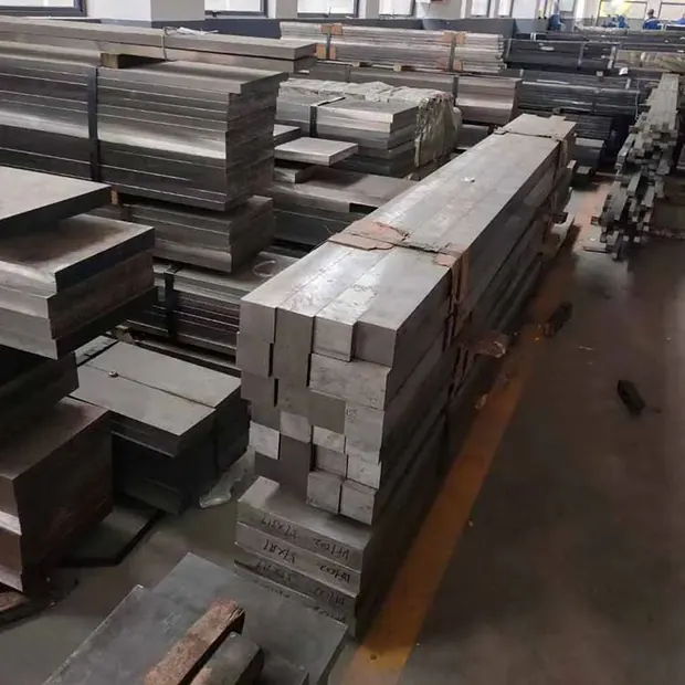Stacked flat steel bars piled on a workshop floor