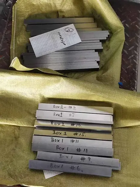 Small steel flat bars wrapped in yellow cloth with handwritten labels