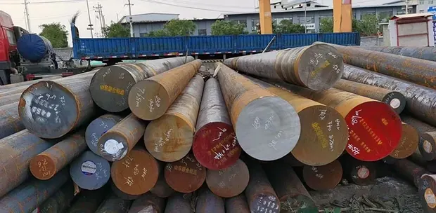 stack of round steel bars with painted ends in an outdoor yard