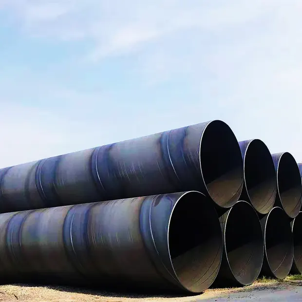 Large spiral welded steel pipes stacked under a blue sky