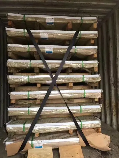Stacked steel sheets strapped onto racks inside a shipping container