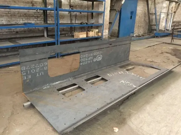 Bent steel plate fabrication with cut slots in a workshop