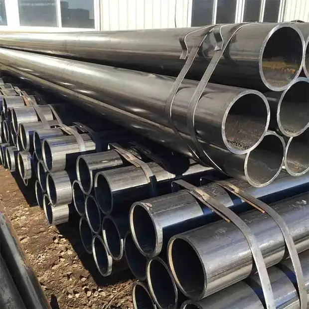 Bundles of black steel pipes in varying diameters stacked outdoors