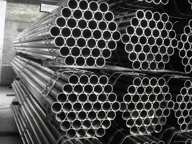 Stacked steel round pipes viewed end-on in tight bundles
