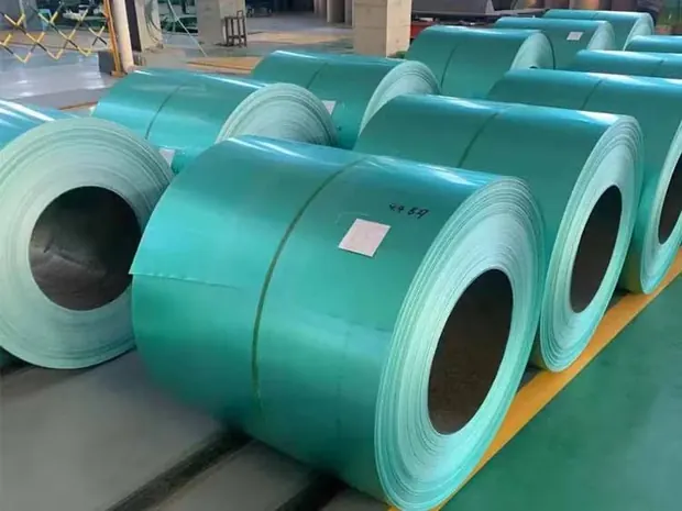 Rows of green pre-painted steel coils stored indoors