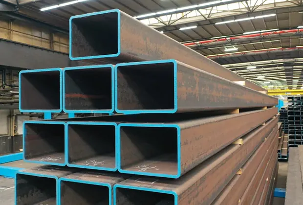 Blue coated square steel tubes stacked in a workshop