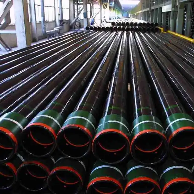 Steel casing pipes with red and green plastic end caps stacked