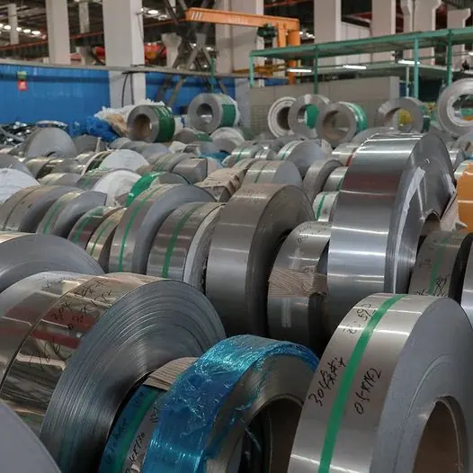 Stainless steel coils bound with straps stacked in storage building
