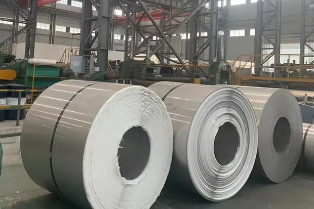 Stacked steel coils standing eye to sky in a mill building