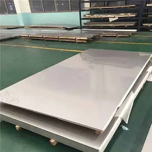 Stainless steel sheets stacked on wooden pallets in a workshop