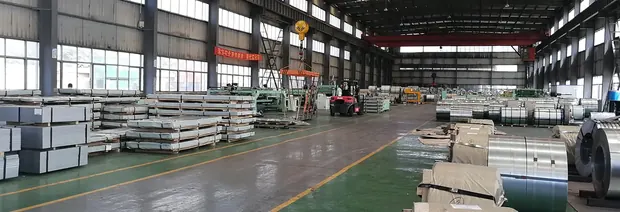 Sheet packs and steel coils stored along a warehouse aisle