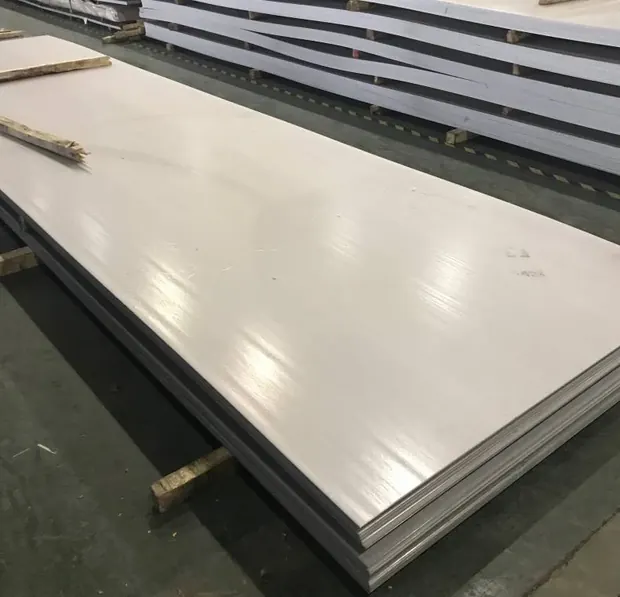 Flat light gray steel sheets stacked on a workshop floor