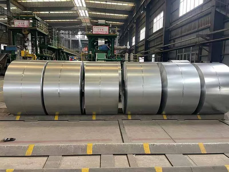 Rows of steel coils stored on a mill floor