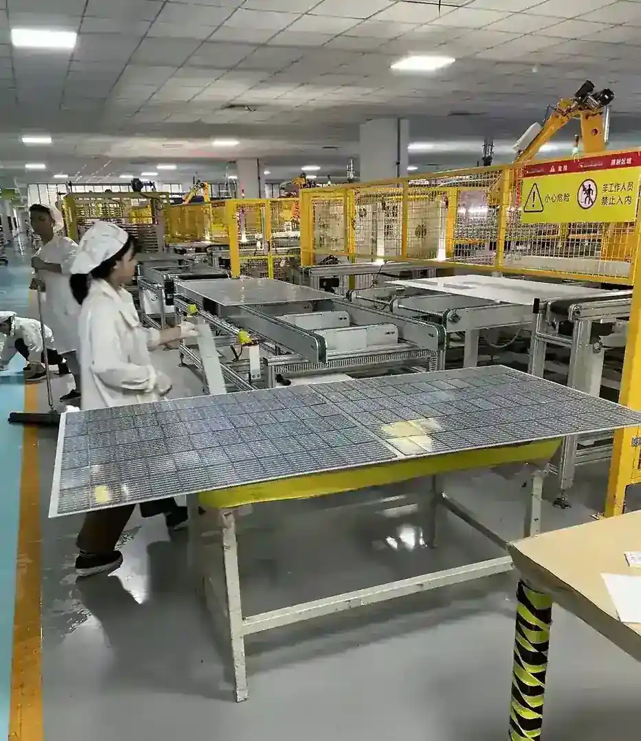 Operators handling laminated modules at the lamination workstation