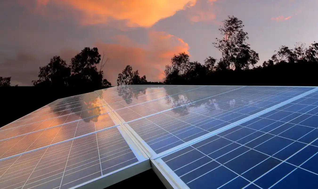 Rooftop solar array on a metal roof at sunset