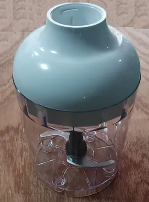 Mint-green lid on a clear chopper bowl with a center blade hub