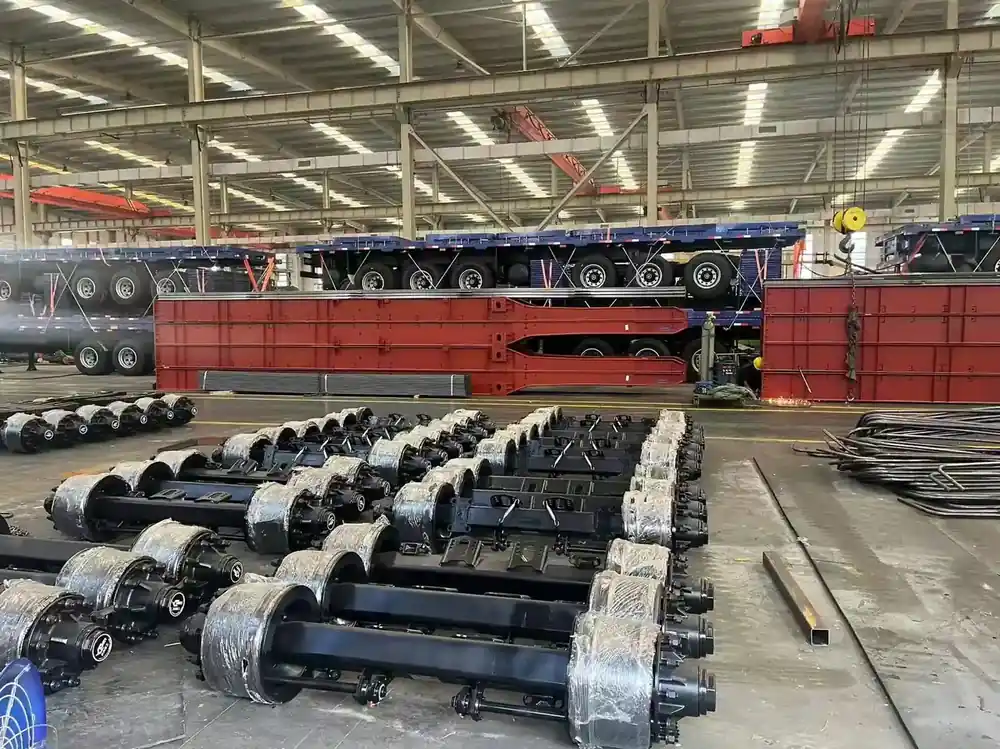 Axle assemblies and finished trailer frames staged inside the SINOHENG assembly workshop