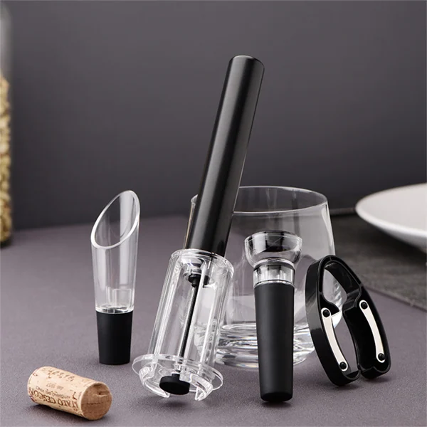A set of four air pressure wine bottle openers and accessories displayed with a glass and cork.
