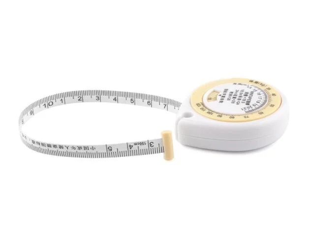 Tape measure laid flat on a white surface with a hand holding the housing