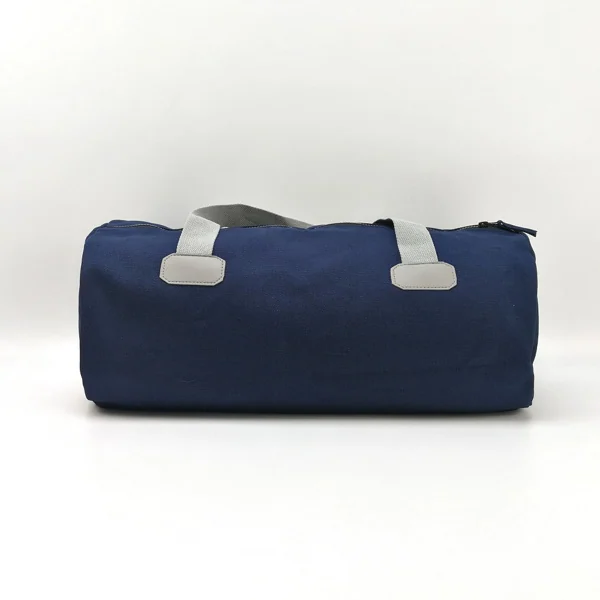 Navy blue canvas duffel bag with gray carry handles and zipper closure on a plain white background