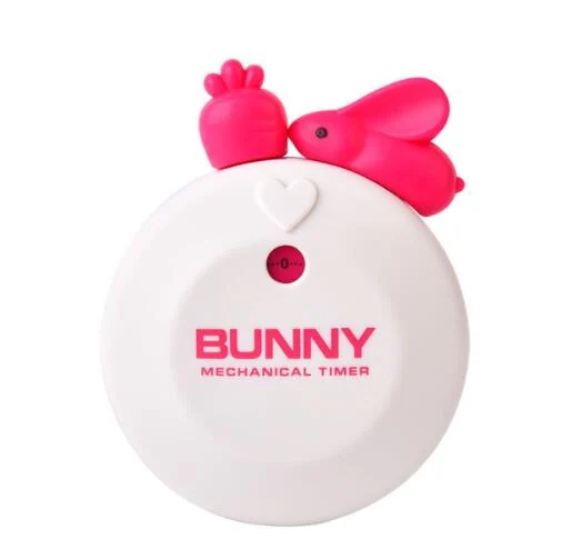 Plum red rabbit timer on a fridge with a note taped to it, showing kitchen use