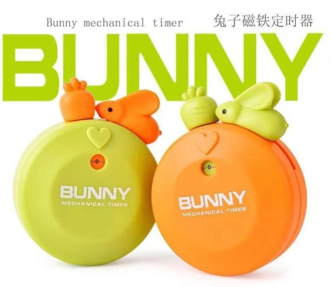 Two round mechanical kitchen timers in green and orange with cartoon rabbit figures on top