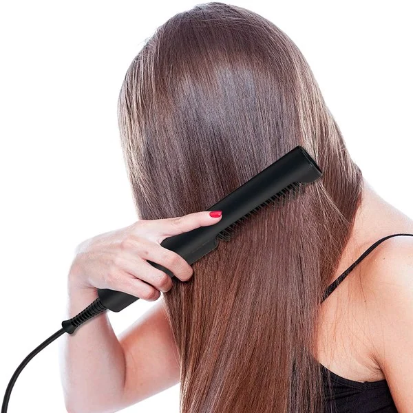 Woman smoothing long brown hair with a black ionic ceramic hair straightener hot comb