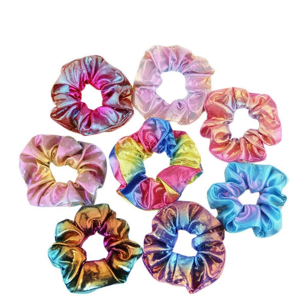 Eight shiny holographic hair scrunchies in pink, rainbow, gold, and blue arranged on a white background