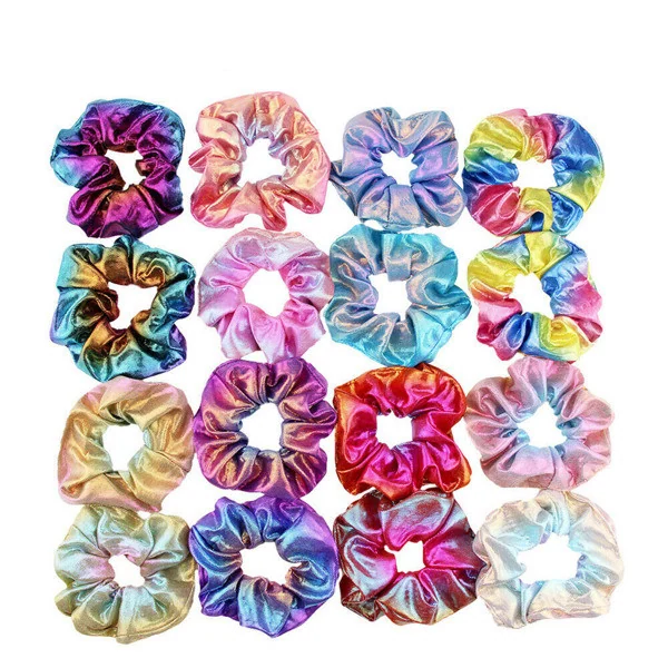 Grid of sixteen colorful satin scrunchies in tie-dye, rainbow, and pastel colors arranged on a white background