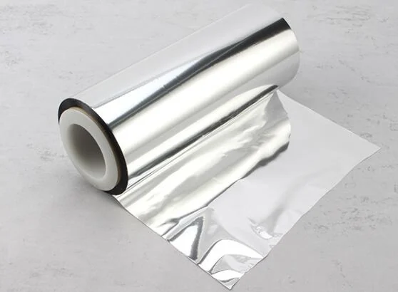 Roll of reflective silver metallized laminated film partially unrolled on a light gray surface