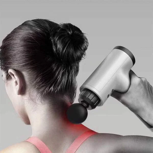 Woman using a white handheld massage gun on her neck and shoulder, with a red glow at the contact point.