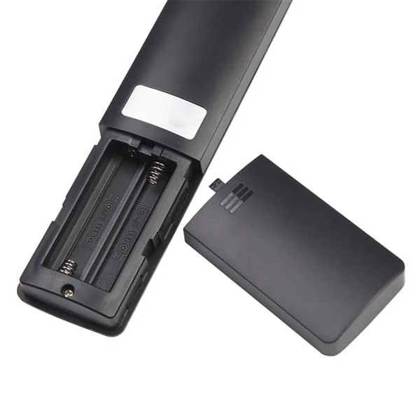 Black thermometer shown from rear with battery cover removed, exposing battery compartment springs and contacts on a white background.