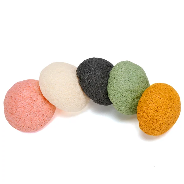 Five teardrop-shaped konjac facial sponges in pink, white, black, green, and orange arranged in an arc on a white background.