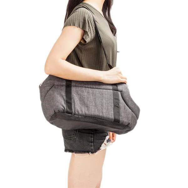 Pet carrier placed on a grassy outdoor surface with a small dog inside