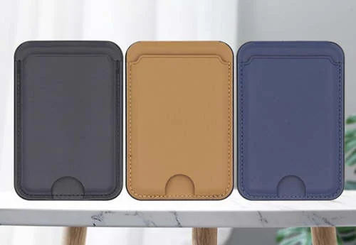 Three leather magnetic phone card holder stands in grey, tan and navy displayed on a marble table