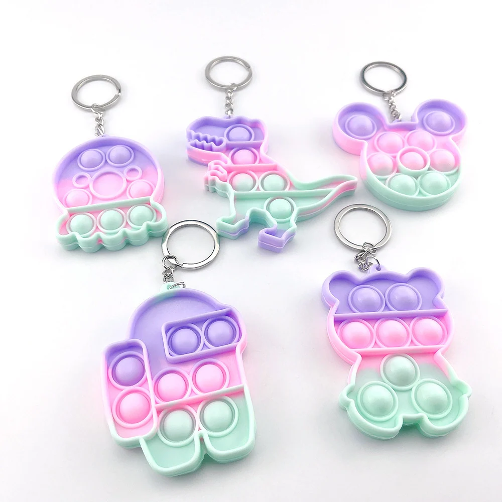 Five pastel gradient silicone pop-it keychains shaped like a dinosaur, bear, and other designs