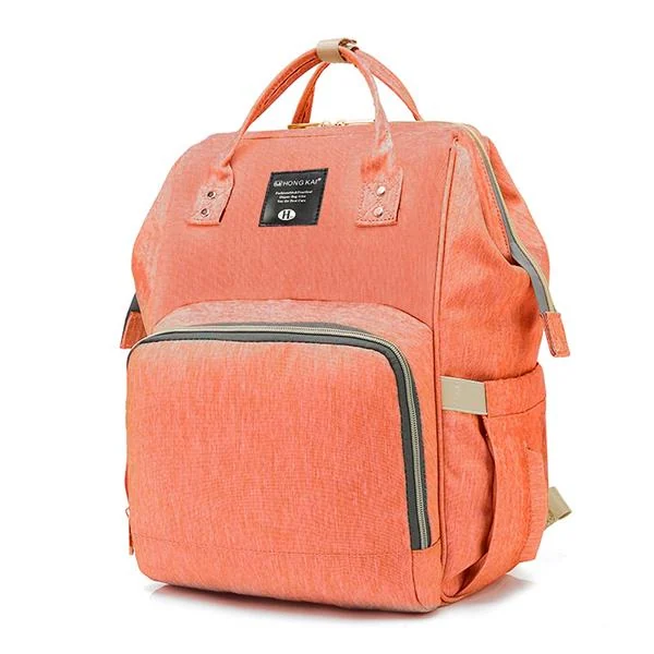 Coral pink multi-function diaper backpack with front zip pocket and top handle on a white background