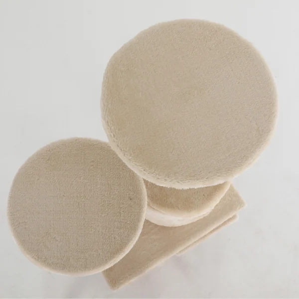 Beige plush round platforms and ramp of a cat tree viewed from above against a white background