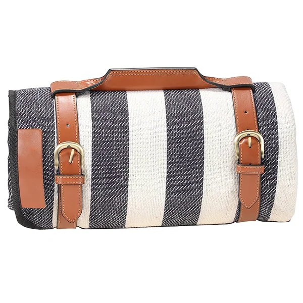 Rolled navy and white striped picnic blanket secured with brown leather straps, brass buckles and carry handle.